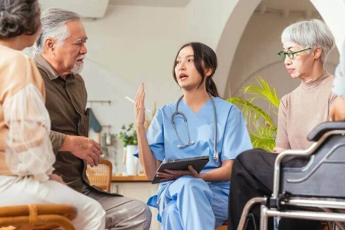 A care professional speaking with an older woman at home.